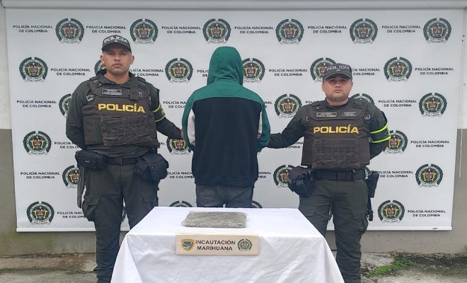 Uniformados de la Policía Nacional presentan a una persona capturada junto a un paquete de marihuana incautado durante un procedimiento de registro y control realizado en Unión Panamericana, Chocó.