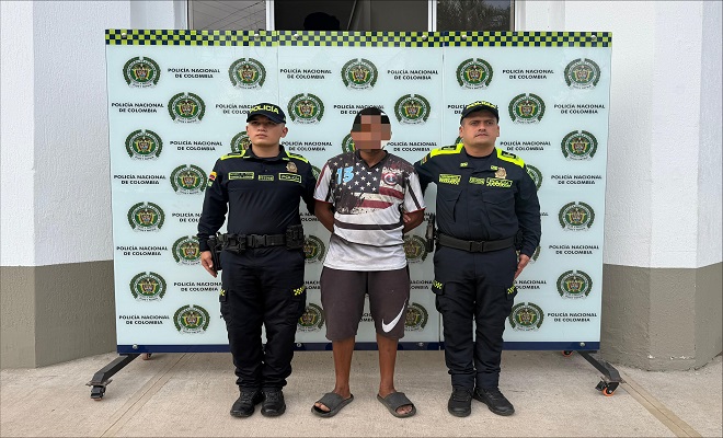 Un ciudadano masculino capturado por orden judicial con dos funcionarios de la Polic&iacute;a Nacional, uno de cada lado brindando seguridad