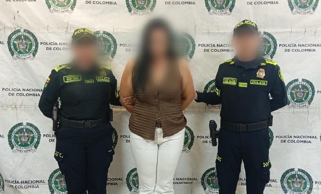 Dos uniformados acompañan a una femenina frente a un fondo institucional