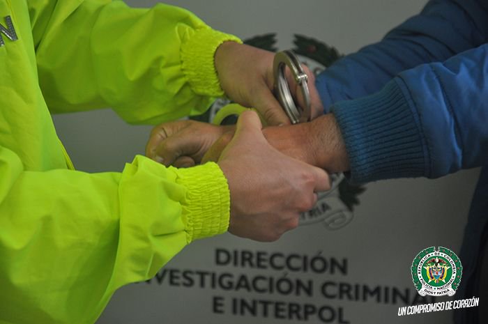 fotografía de un policía colocandole esposas a una persona