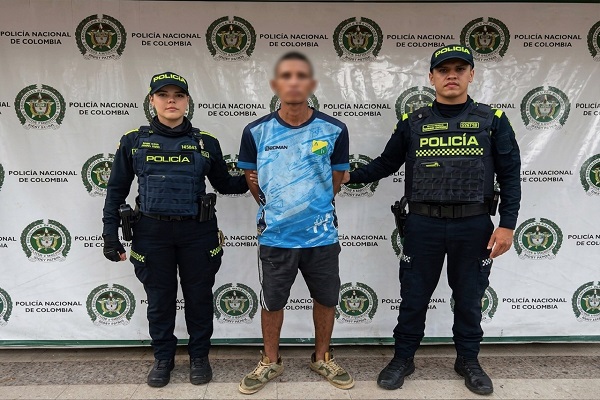 Dos polic&iacute;as custodian a un hombre capturado