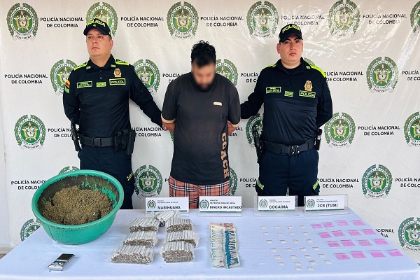 Dos Polic&iacute;as, un capturado, mesa con la incautaci&oacute;n de estupefacientes