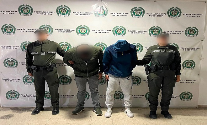 Dos polic&iacute;as al lado de dos presuntos delincuentes sindicados de hurto 