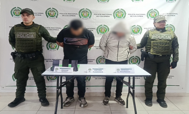 Dos personas capturadas esposadas con dos polic&iacute;as en cada lado 