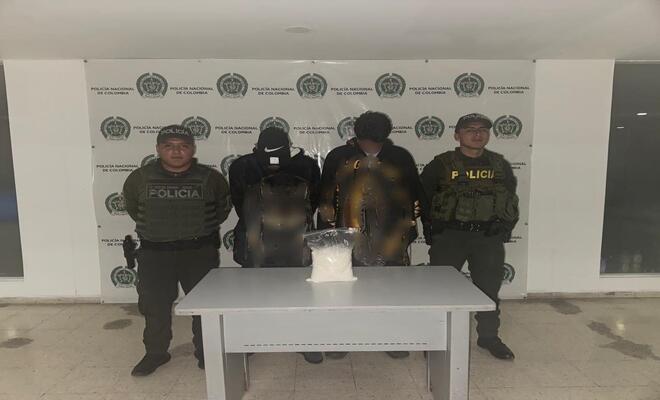 Dos policías con  dos personas Capturadas por tráfico de estupefacientes 