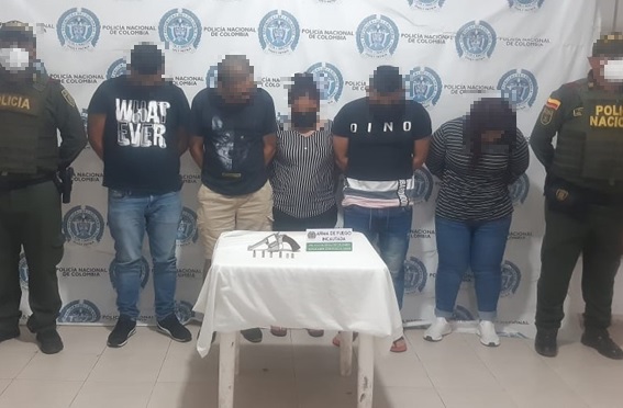 5 personas capturadas-policías custodiando-arma de fuego incautada