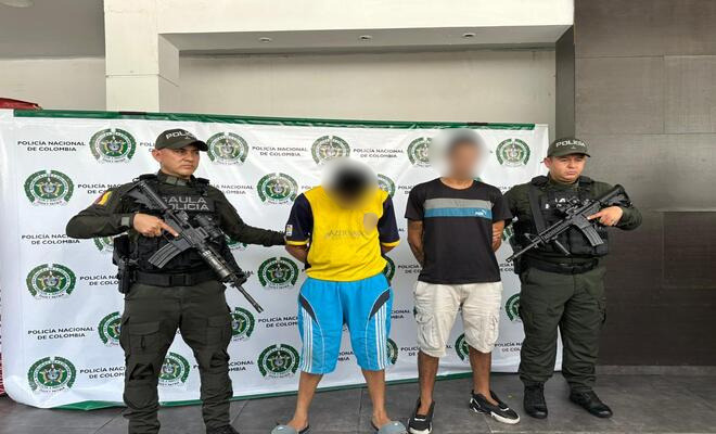 Dos capturados sujetados por dos uniformados de la Polic&iacute;a Nacional