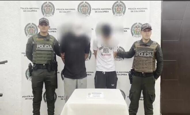 Dos personas capturadas por hurto y esposadas con dos Polic&iacute;as a sus lados respectivamente 