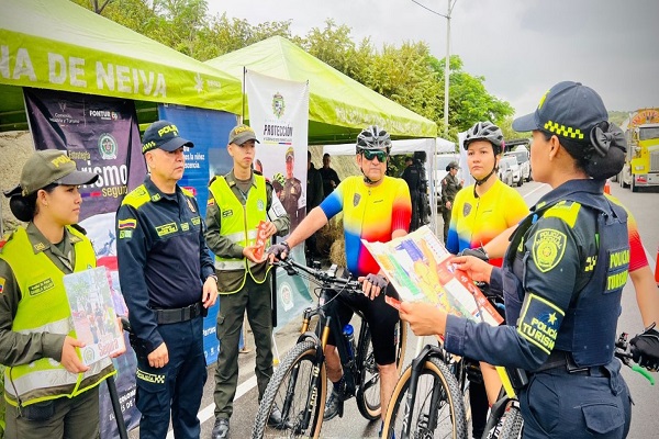Cuatro Policías de turismo realizando socialización a dos ciudadanos en el marco de la estrategia Semana Santa Segura