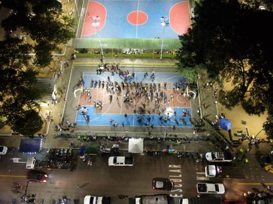 Toma aérea de policías realizando intervención en cancha deportiva y sus alrededores para prevenir el delito