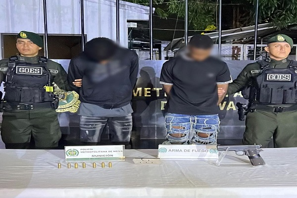 Dos Polic&iacute;as custodian a dos capturados y arma de fuego incautado