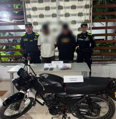 dos policías al lado de un hombre capturado y recuperación de motocicleta