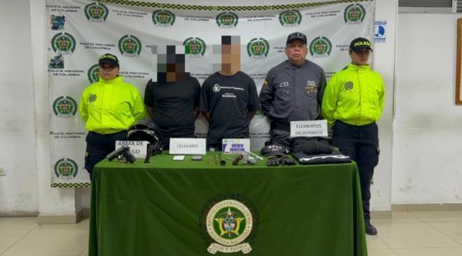dos policías, un funcionario del CTI, al lado de dos personas capturadas y elementos incautados.