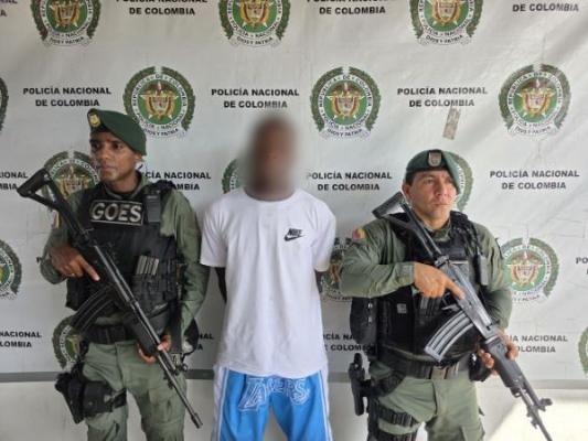 dos policías al lado de un hombre capturado