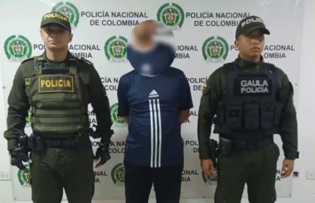 Dos policías al lado de un hombre capturado