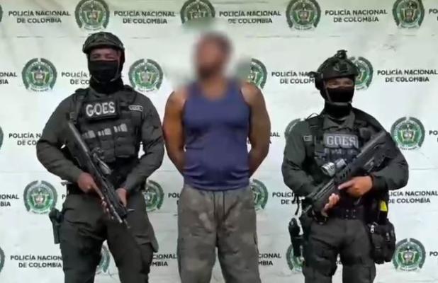 Dos polic&iacute;as al lado de un hombre capturado