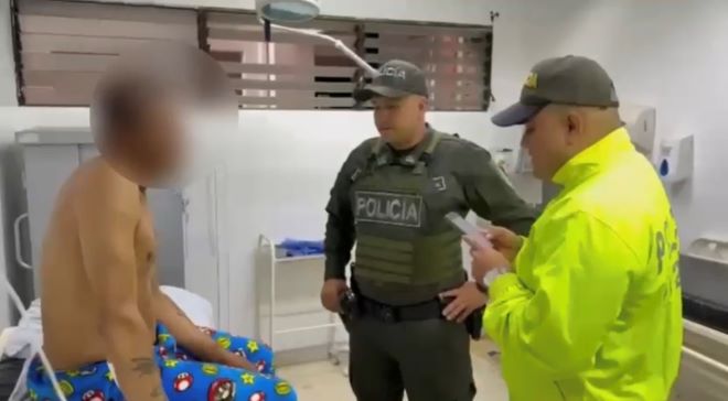 dos polic&iacute;as al lado de un hombre capturado