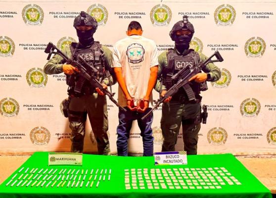 dos policías al lado de un hombre capturado con estupefacientes