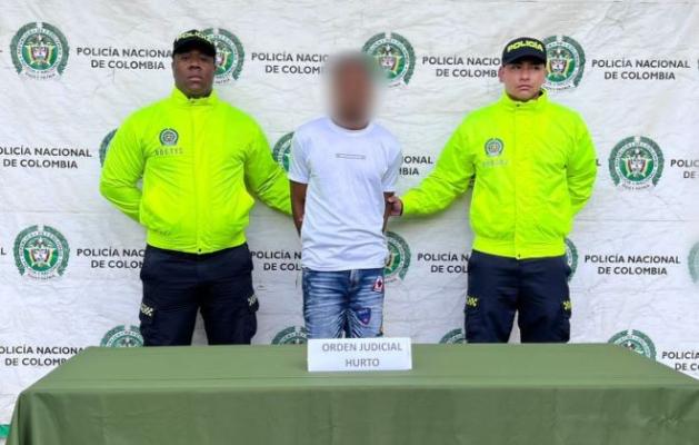 Dos policías al lado de un hombre capturado por hurto