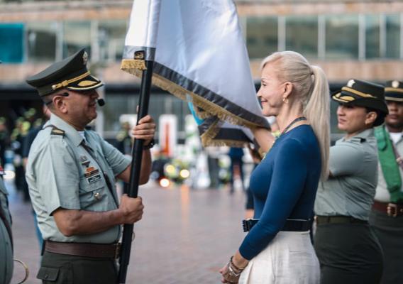 el señor coronel al lado de la señora gobernadora recibiendo la bandera del departamento del valle del cauca