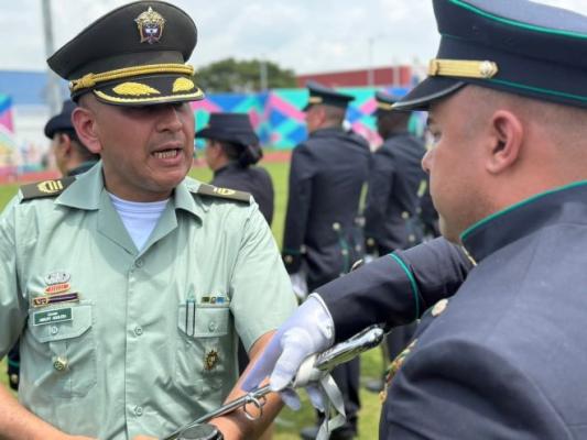 el señor coronel realizando la entrega del sables al uniformado
