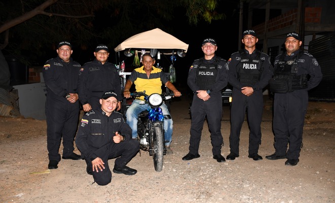 Uniformados acompañan a un ciudadano beneficiado junto a su nuevo medio de transporte.