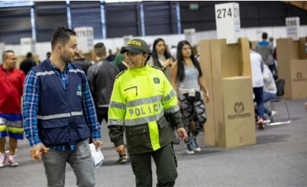 foto de un polic&iacute;a con un delegado de la registradur&iacute;a en los puesto de votaci&oacute;n.