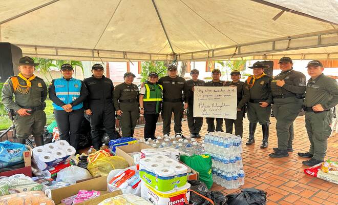 Policías posan junto a las ayudas recolectadas durante una campaña de apoyo comunitario.