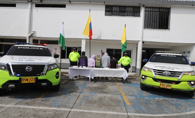 Miembros de la SIJIN custodia personas capturadas en la mesa elementos incautados  y a los dos costados dos veh&iacute;culos uniformados