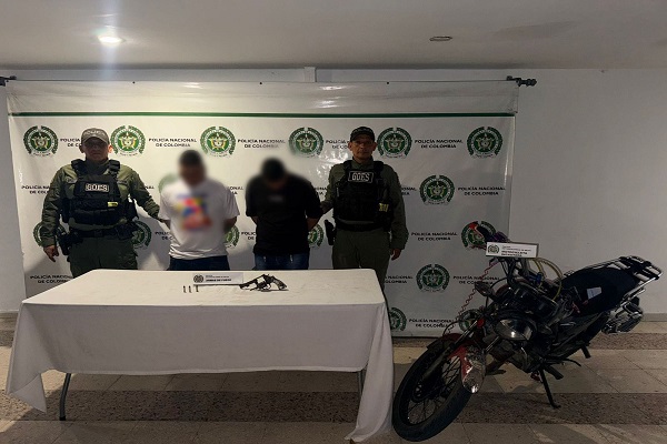 Dos Policías, dos hombre capturados por porte de arma y una motocicleta