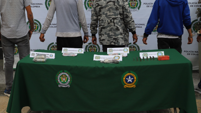 9 personas capturadas-policías custodiando-moto inmovilizada