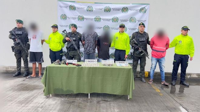 la policía nacional al lado de cuatro personas capturadas