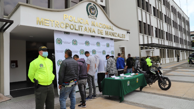 9 personas capturadas-policías custodiando-moto inmovilizada