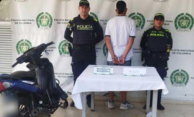 Hombre capturado en medio de dos Polic&iacute;as en frente motocicleta recuperada