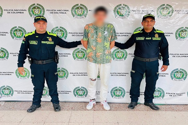 Dos policías custodian a un hombre capturado por orden judicial