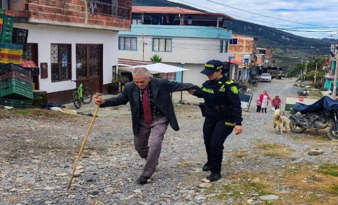 un polic&iacute;a en horas de la ma&ntilde;ana ayudando a un se&ntilde;or a que llegue a su punto de votaci&oacute;n y pueda ejercer su derecho al voto