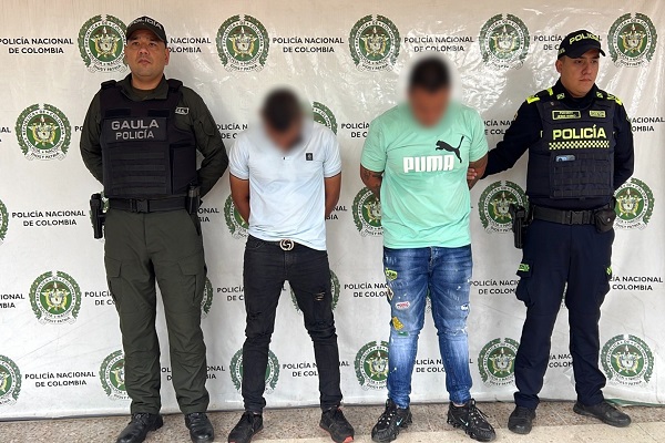 Dos polic&iacute;as custodian a dos hombres capturados se&ntilde;alados de presunto secuestro