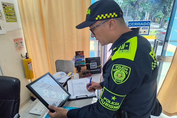 Policía de turismo verificando documentación en agencia de viaje