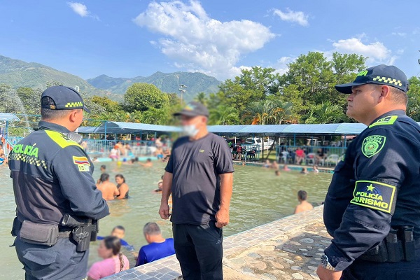 Dos Policías del Grupo de Protección al Turismo y Patrimonio compartiendo recomendaciones a ciudadano en balneario