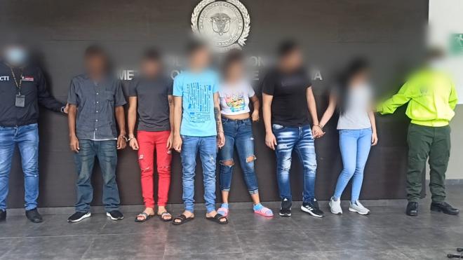 Personas capturadas-policías custodiando