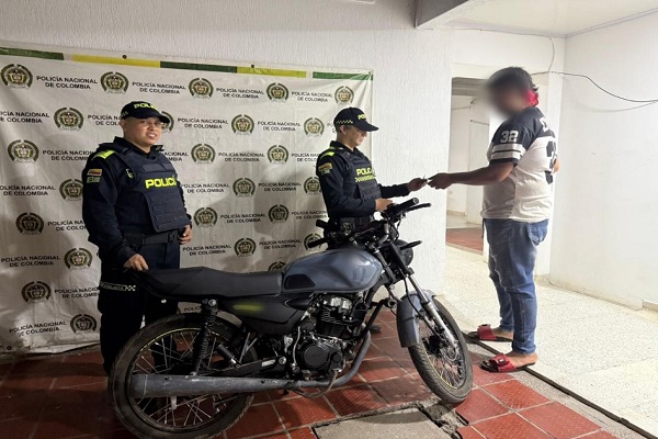 Dos Policías haciendo entrega de una motocicleta recuperada al propietario en Palermo 