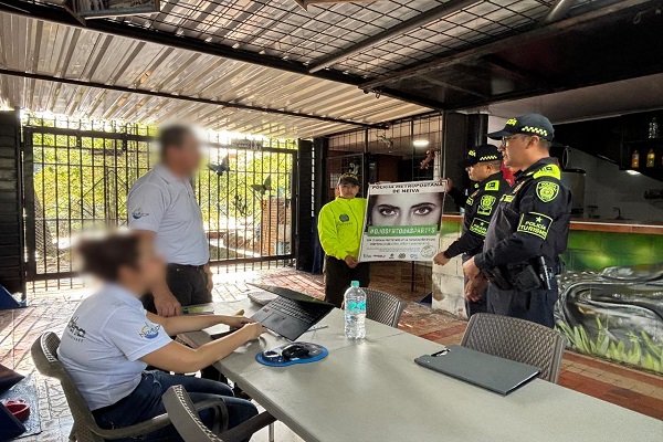 Dos Policías de turismo y una de la SIJIN realizando campaña preventiva contra la explotación sexual de menores a dos ciudadanos 