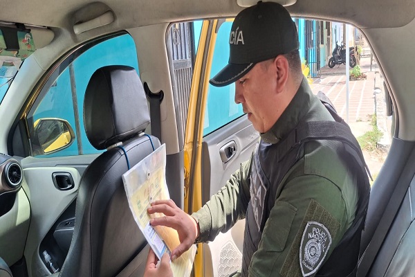 Policía compartiendo afiche Antiextorsión en vehículo de un ciudadano