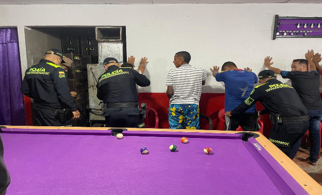 policías realizando registro a personas dentro de un establecimiento abierto al publico