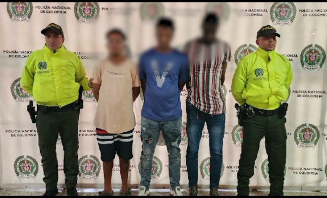 Personas capturadas-policías custodiando