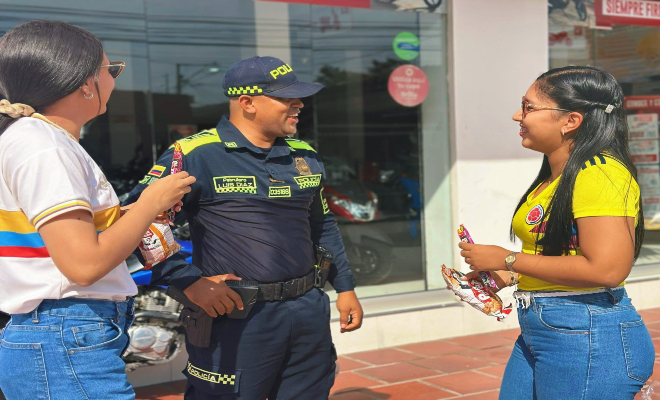 uniformado dialogando con dos ciudadanas en la mañana sobre el orgullo de la camisa que llevan puestas