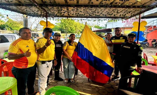 uniformados y ciudadanos sostienen la bandera de Colombia como s&iacute;mbolo de orgullo y amor